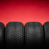 Car tires, winter wheels isolated on red background