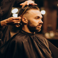 Young man at barbershop trimming hair